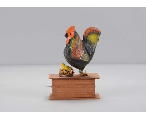 A mid to late 19th century Thüringen chicken and chick crank toy,  with green and red composition chicken with spring legs, a