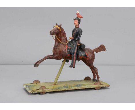 A second quarter of 19th century Thüringen composition Soldier on horse pull along toy,  probably an English lancer with navy
