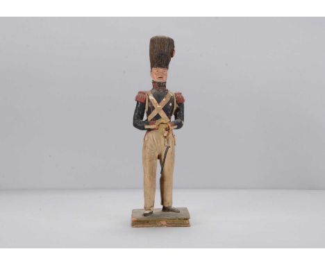 An early 19th century papier-mâché Napoleonic French Infantryman,  with busby, blue painted eyes, open mouth, blue jacket wit