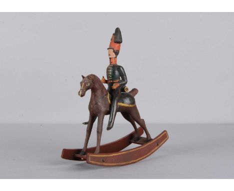 A mid 19th century Thüringen composition and wood British mounted Hussar soldier rocking toy, in blue uniforms with tall shak