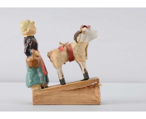 A late 19th or early 20th century shepherdess squeak toy, possibly French, composition shepherdess in blue outfit holding bas