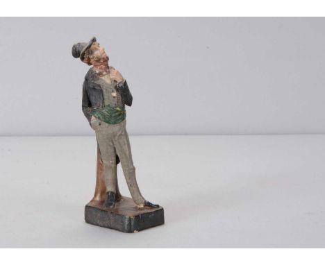A late 19th century Thüringen gentleman   in top hat,  composition standing looking up with crumpled top hat, a red scarf wra