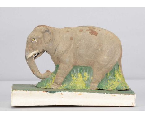 A mid 19th century Thüringen elephant squeak toy,  papier-mâché grey flocked finish, green painted undergrowth between legs, 