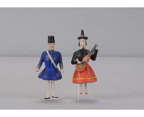Two late 19th century German bristle dancing toys, wooden with composition heads, one a woman with tinted hat playing a guita