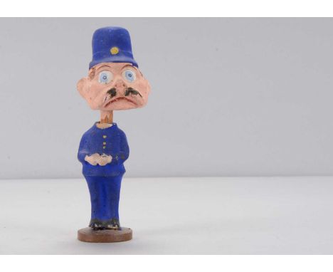 An early 20th century Thüringen Palmer Cox Brownie policeman nodder,  composition with large blue glass eyes, moustache, blue
