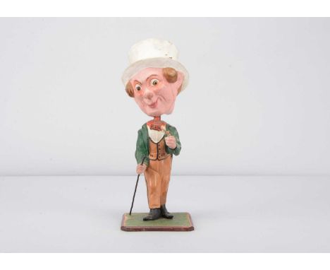 A mid 19th century German papier-mâché large headed Dandy gentleman nodder, with two curls of blonde hair either side of temp