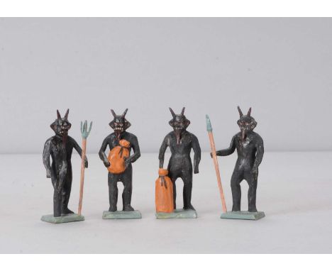 Four late 19th or early 20th century Erzgebirge Krampus figures, black painted wooden figures with horns and long tongues, tw