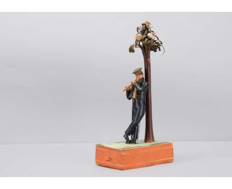 An 1830s Sonneberg papier-mâché and wood hand-cranked mechanical toy of a student playing a flute,  the young man standing wi