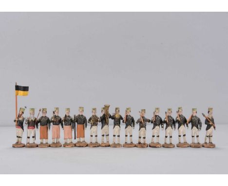 Sixteen late 19th century German composition marching Miners,  comprising a grey bearded leader and brown bearded flag bearer