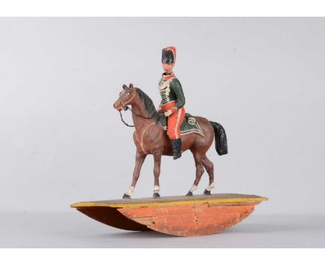 A mid 19th century Thüringen composition Soldier on horse rocking toy, with nodding head, Hussar uniform with busby, green ja