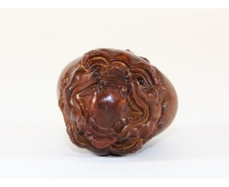 A carved fruitwood netsuke of a double headed dragon with black onyx eyes, L 5cm