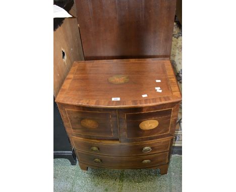 A George III mahogany commode in the form of a bow front  chest, crossbanded hinged top, two doors over faux drawers, later d