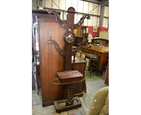 A Victorian mahogany tree hall stand, four reticulated branches, circular mirror, glove box and stick stand to base.