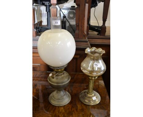 A brass oil lamp with globe and funnel; a brass candle lamp