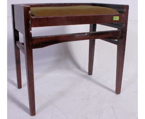 A 1950's metamorphic mahogany piano stool. Raised on turned legs with an adjustable upholstered seat above. Measures: 54 x 58