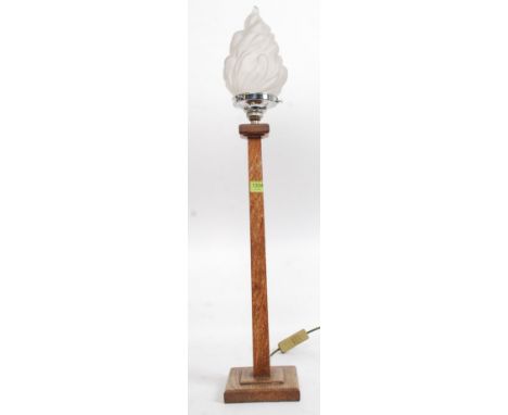 A stunning Art Deco oak table lamp of simple form standing on a square base, having a frosted torch flame glass shade. Measur