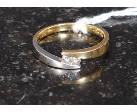 An 18ct gold 750 marked ladies diamond ring of contemporary cross over form with 2 cushion cut diamonds approx 20pnts. Total 