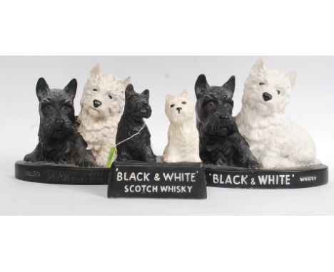 A collection of Black & White Scotch Whisky dog figurines to include 2 ceramic, 1 being resin. Largest H22cm