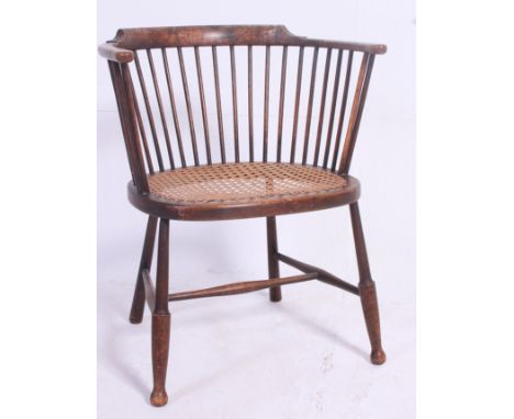 AN EARLY 20TH CENTURY WINDSOR STYLE STICK BACK CHAIR having a stick back, cane seat and splayed legs united by an H framed st