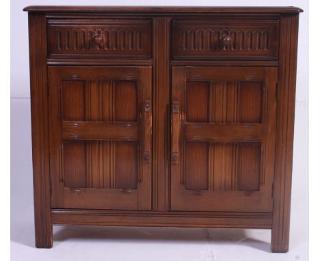 A dark Elm Ercol sideboard , having panel doors below two drawers.  Measures: 82 x 92 x 41