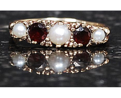 A 9ct gold, seed pearl and ruby stone ladies dress ring. Stamped to interior shank, the pearls and stones on gypsy setting Si