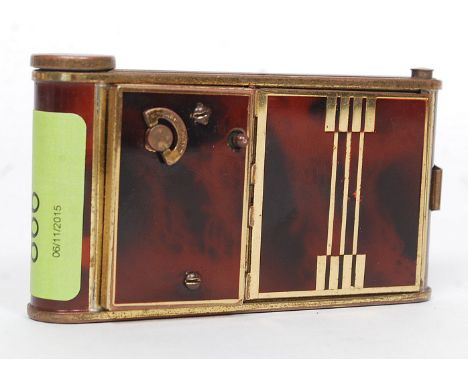 A 1930's Art Deco ladies musical - manicure combination compact having faux tortoiseshell and laquered brass inlaid detail W1