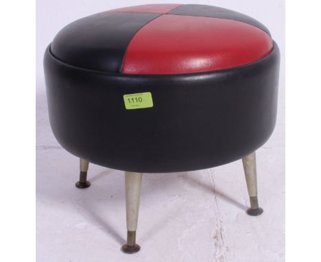 A retro two tone vinyl red and black footstool pouffe, standing on tapered retro legs. H34 x W38 cm 