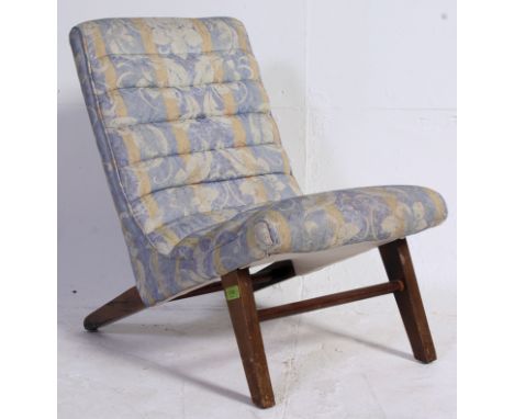 A vintage 1940's upholstered childs nursing chair raised on angled beech wood legs with ribbed chintz upholstered frame above