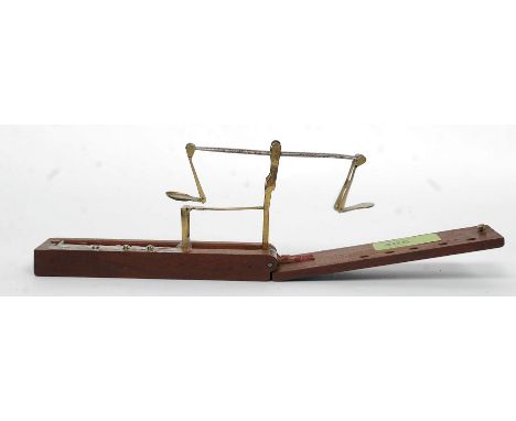 A small set folding coin scales set within a mahogany case. With weights etc W25cm