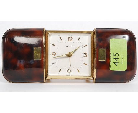 ESTYMA; a vintage simulated tortoiseshell cased self winding travelling clock, the rectangular dial set with batons and Arabi