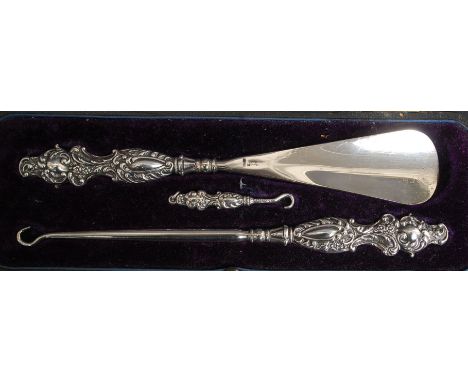 A cased silver hallmarked set of button hooks and shoe horn. Birmingham hallmarks for Adie & Lovekin 1909. Original black mor