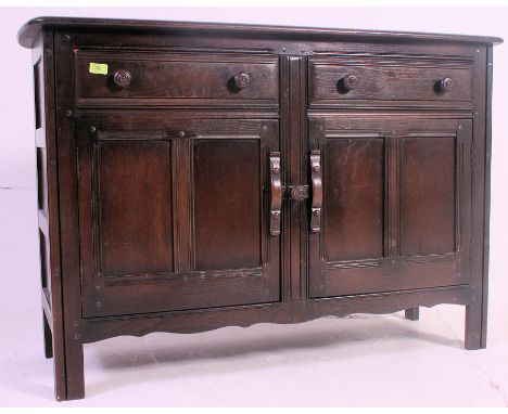An Ercol Jacobean beech and elm wood dresser sideboard. Raised on squared legs with short drawers and cupboard. Measures: 84 
