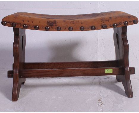 An early 20th century  leather button back stoo over oak base united by stretchersl. H47 x W62 x D33 cm 