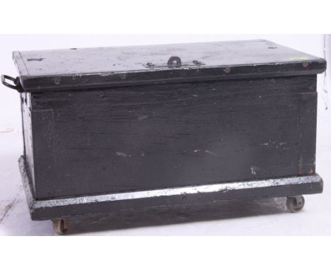 A vintage ebonised pine tool box / trunk having a hinged top being raised on later castors. Measures: 33 x 59 x 36.
