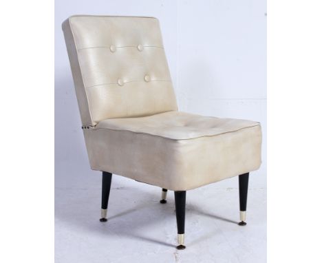 A vintage 1950's retro faux cream leather chair having button backed upholstery being raised on ebonised sputnik style legs. 