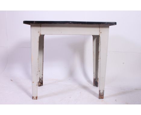 A retro 1950's Industrial metal and enamel top table. Raised on tapered legs with white enamel painted top. Measures: 76 x 84