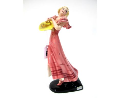 A Goldscheider Pottery Figure, designed by Dakon, modelled as a lady in a dancing pose, wearing a pink dress and holding a ye