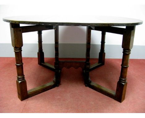 A Nigel Griffiths Oak Gateleg Table, with oval top, double gate action, central trestle supports united by as stretcher, labe