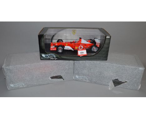 Three Hot Wheels Racing 1:18 scale diecast models: F2003-GA Rubens Barrichello; F2003-GA Michael Schumacher; Jaguar R4 Mark W