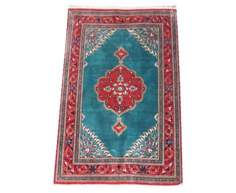 EXTREMELY FINE QUM PART SILK RUG, 120cm x 78cm, pendant medallion on a green field with spandrels, bands and borders.