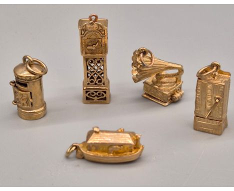 Five various 9ct yellow gold charms; Grandfather clock, Gramophone, Moses ark, Punch Show and post box. [24.38grams]