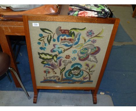 A framed Firescreen with needlepoint floral panel, 23'' wide x 31 1/2'' high.
