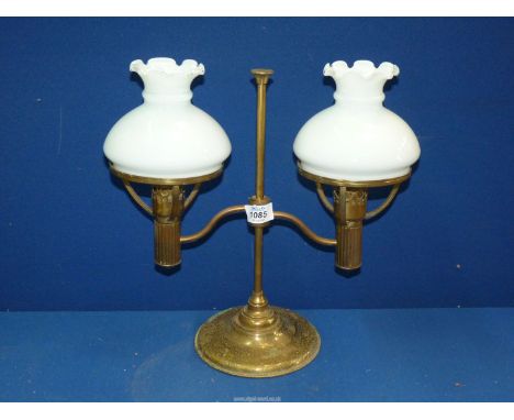 A brass double desk lamp with white glass shades.