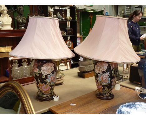 A pair of china table lamp bases , black ground with large pink flowers, with pink shades, 26'' tall including shades.