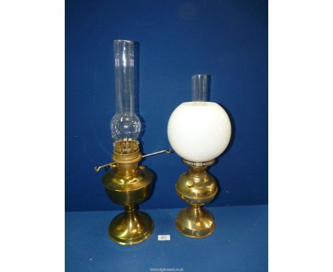 An Aladdin oil lamp with brass base and chimney 23" tall and another with white globe shade.