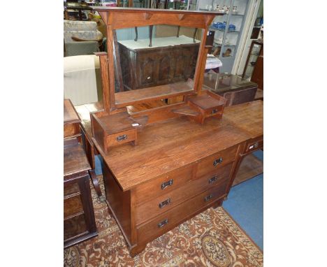An Oak Dressing Chest having two long and two short drawers, the swing mirror raised on shelves with trinket drawers, 42'' wi