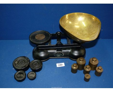 A set of Salters weighing scales with a quantity of metric weights and four imperial weights.