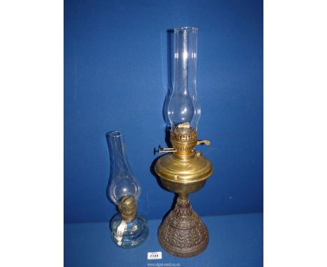 A cast metal base Oil lamp with brass reservoir and clear chimney, plus another smaller oil lamp with chimney.
