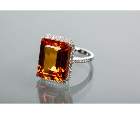 IMPRESSIVE ORANGE SAPPHIRE AND DIAMOND CLUSTER RING
the central emerald cut orange sapphire approximately 13 carats, surround