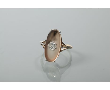 EARLY TWENTIETH CENTURY QUARTZ AND DIAMOND RING
with an oval shaped section of smoky quartz and a central diamond measuring a